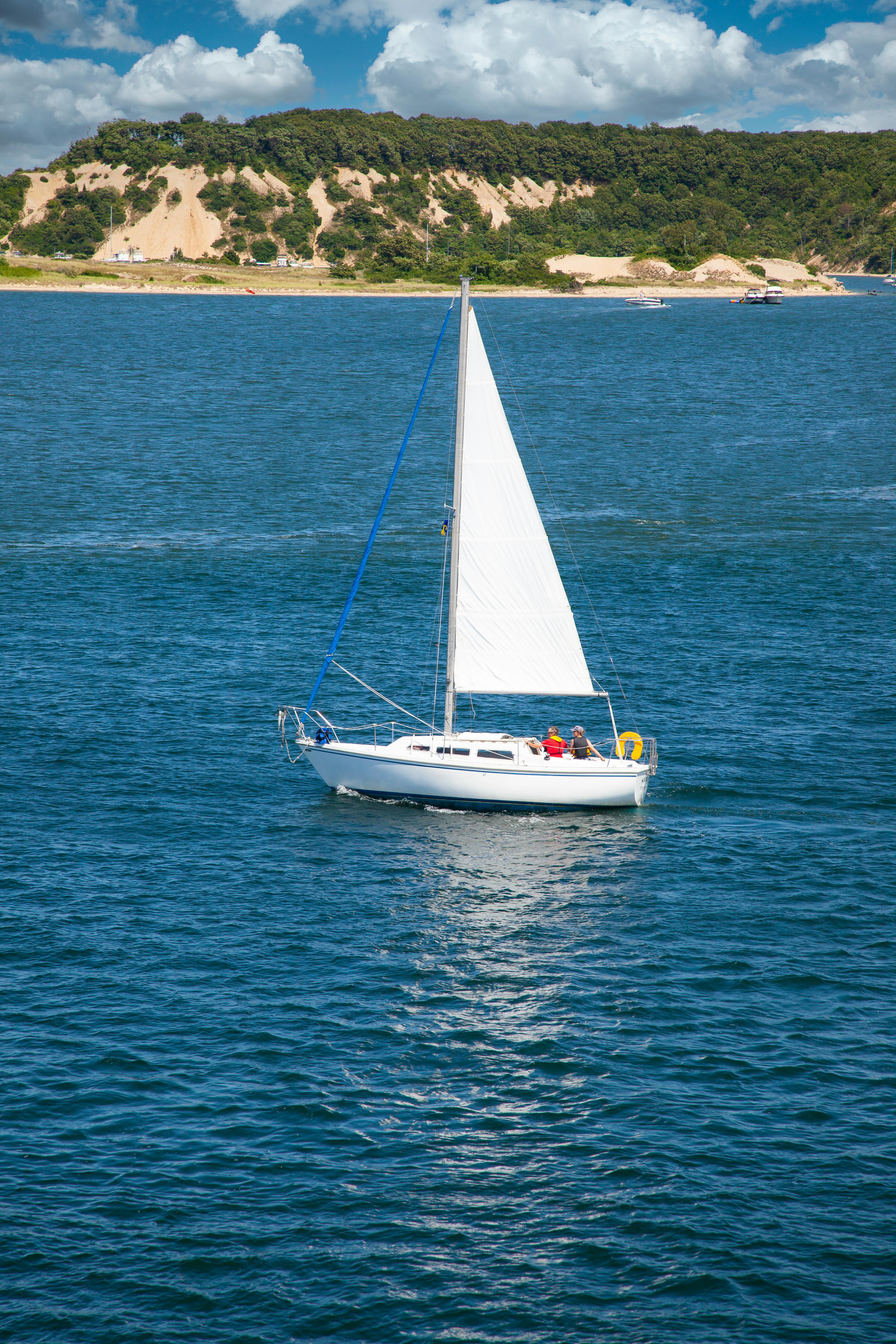 Free A white sailboat with people enjoying a summer day on the ocean near New York. Stock Photo