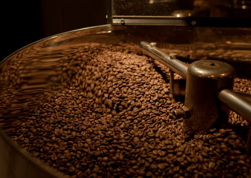 Free Freshly roasted coffee beans in motion inside a roaster. Stock Photo