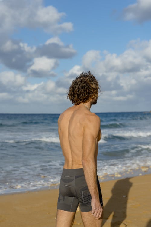 Homem De Topless De Short Preto Em Pé Na Praia