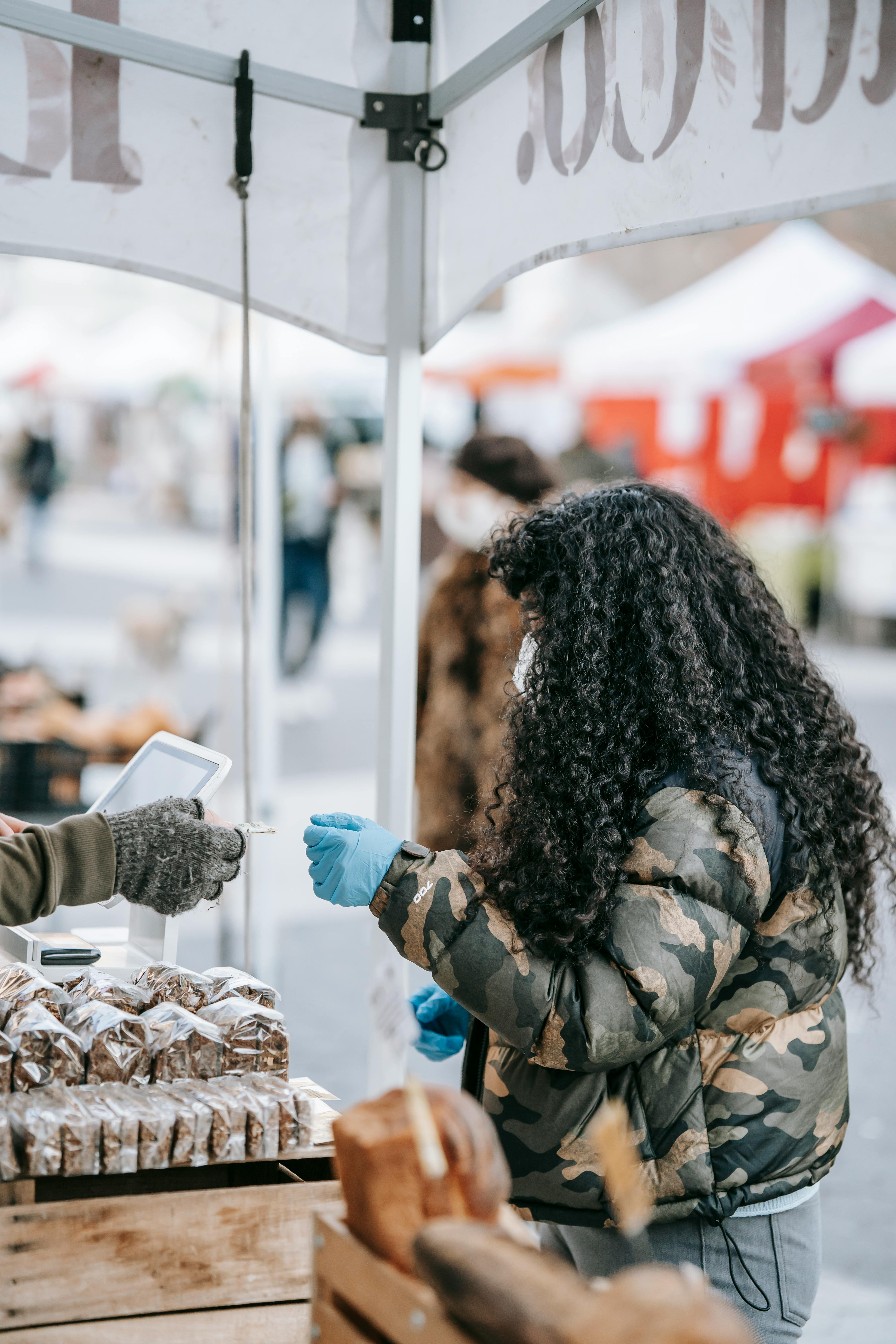 curly woman buying food in street market