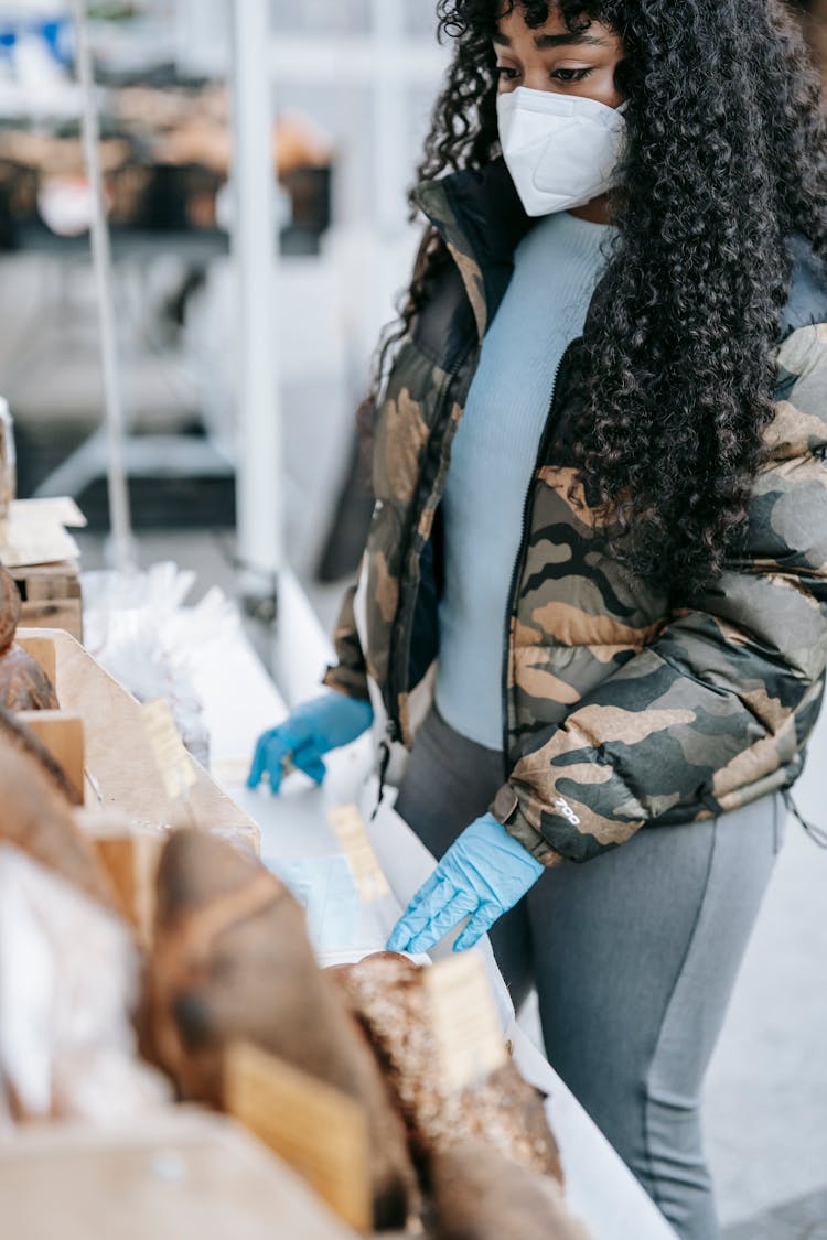 Ethnic Woman Buying Bread In Street Market