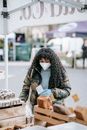 Woman in mask with shopping bag near bakery