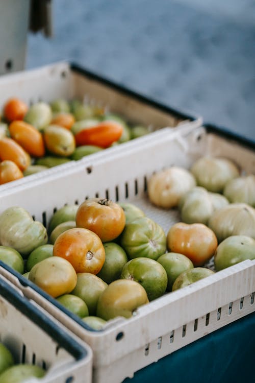 Boxes with green tomatoes in market