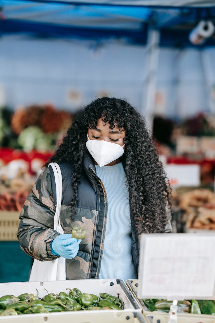 Black Woman In Medical Mask Choosing Anaheim Pepper