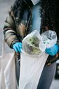Crop unrecognizable woman putting ripe vegetables in shopping bag