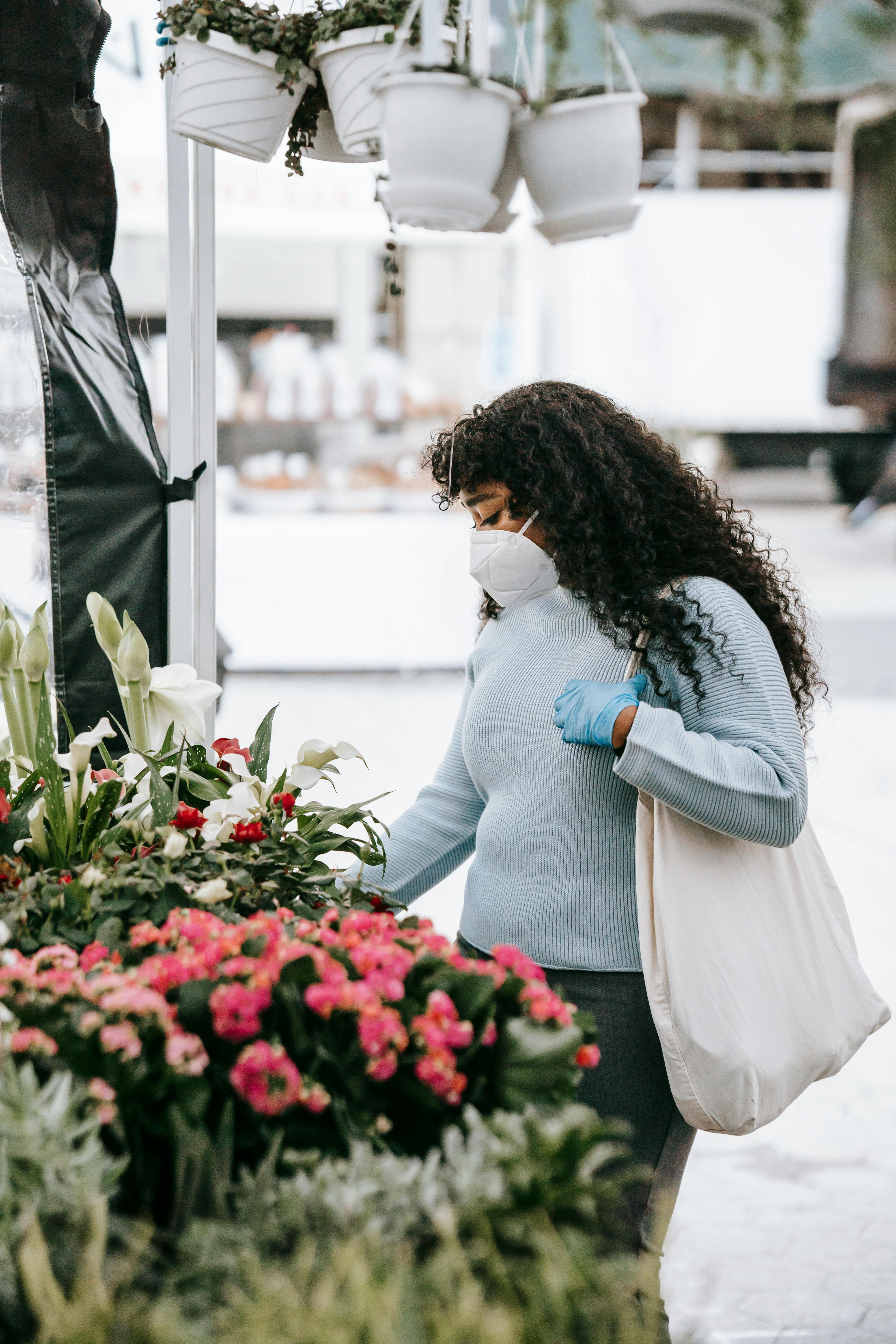 black woman picking tender flowers in outdoor florist shop