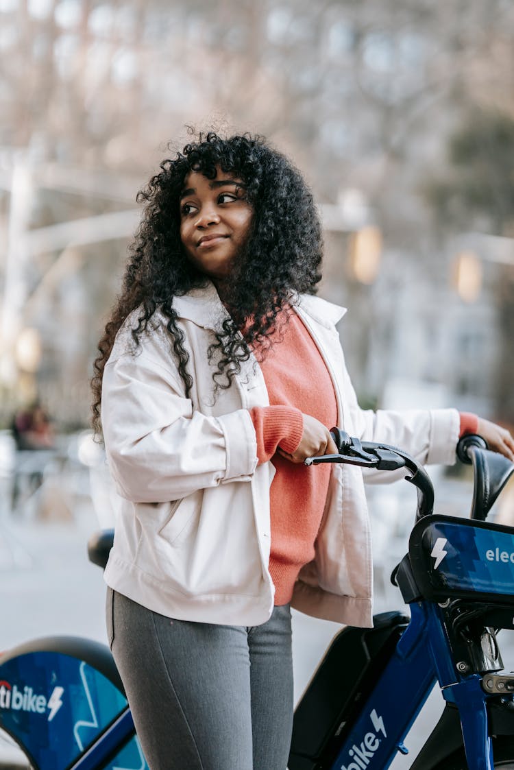 Content Black Woman With Bicycle Standing On Street