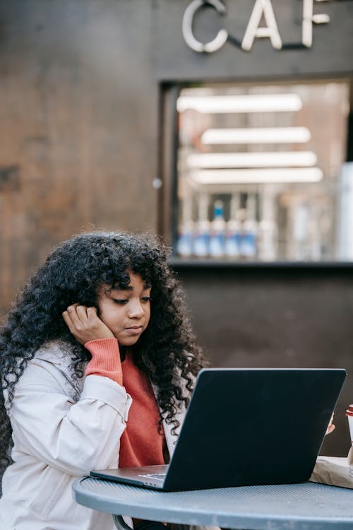 Wanita Berjaket Putih Menggunakan Komputer Laptop Hitam