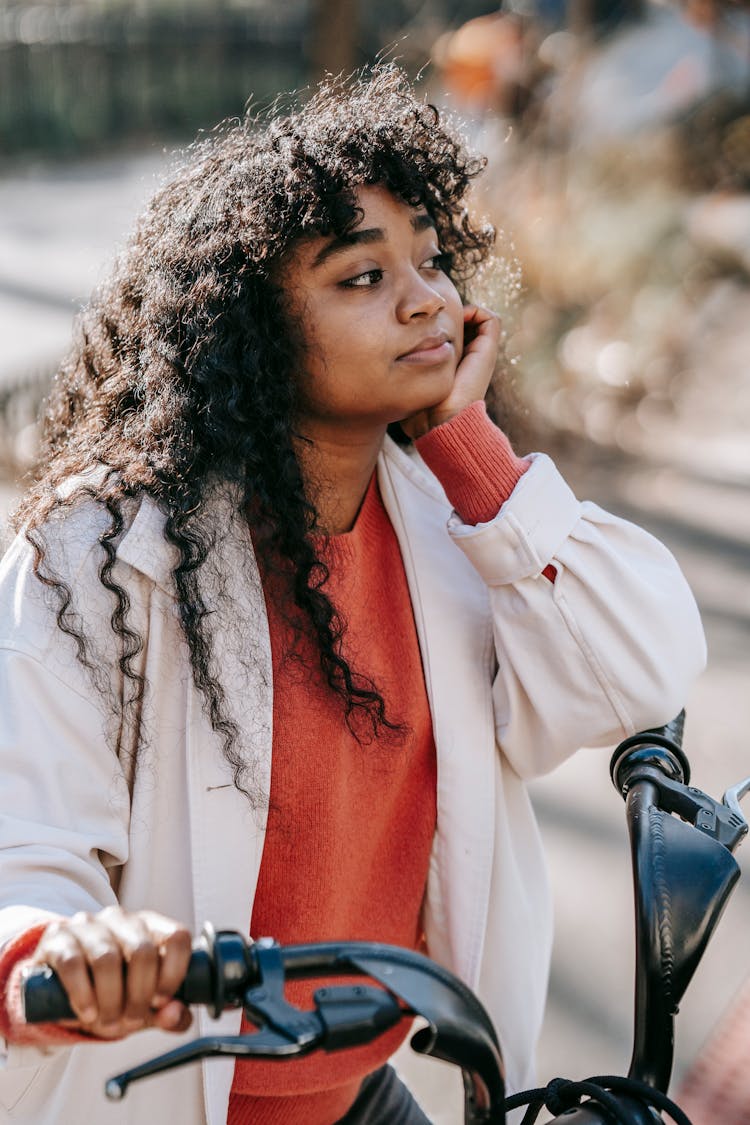 Dreamy Black Woman On Bicycle In City Street