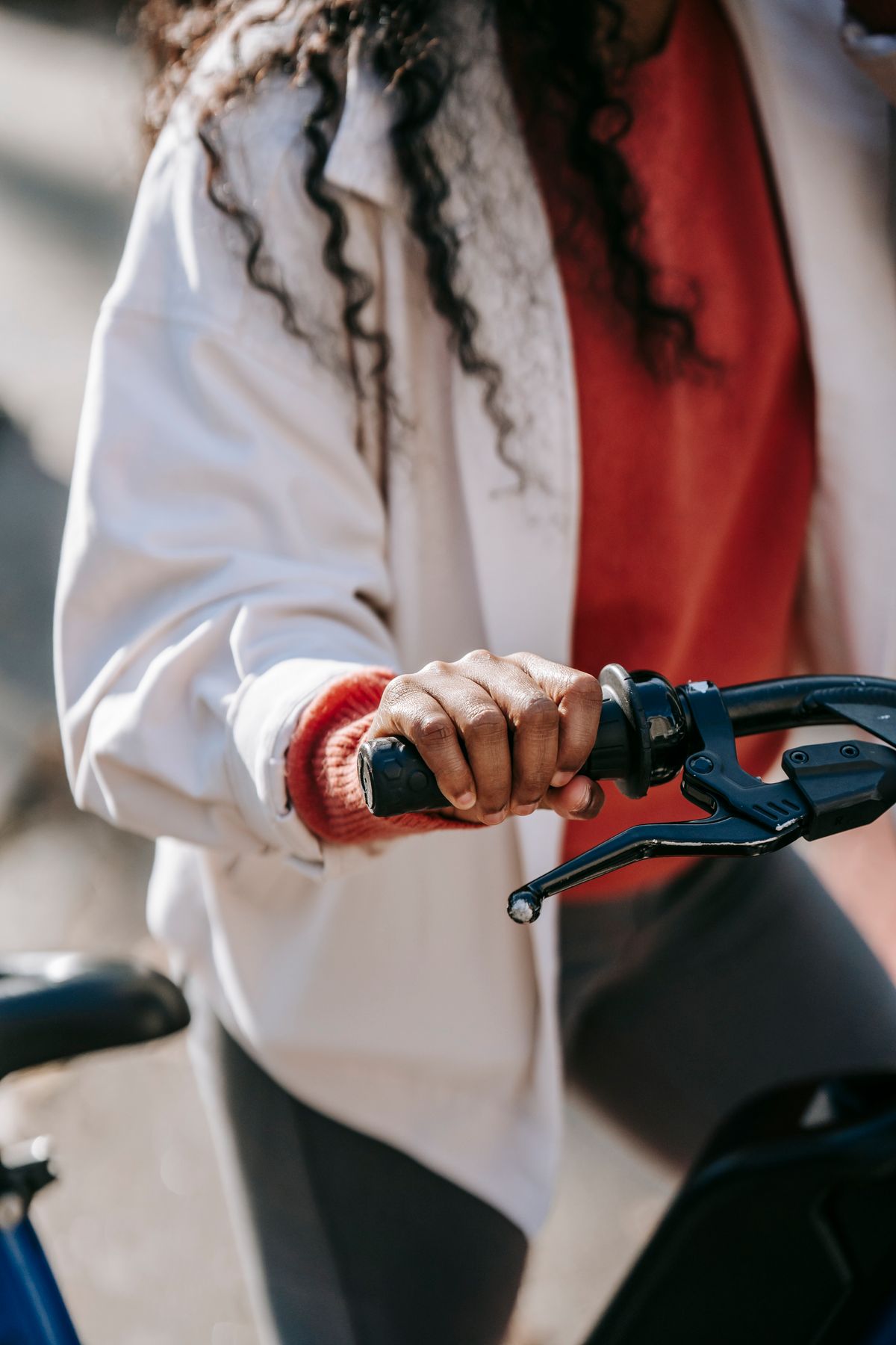 Cyclist holding bicycle handlebars on a sunny city street