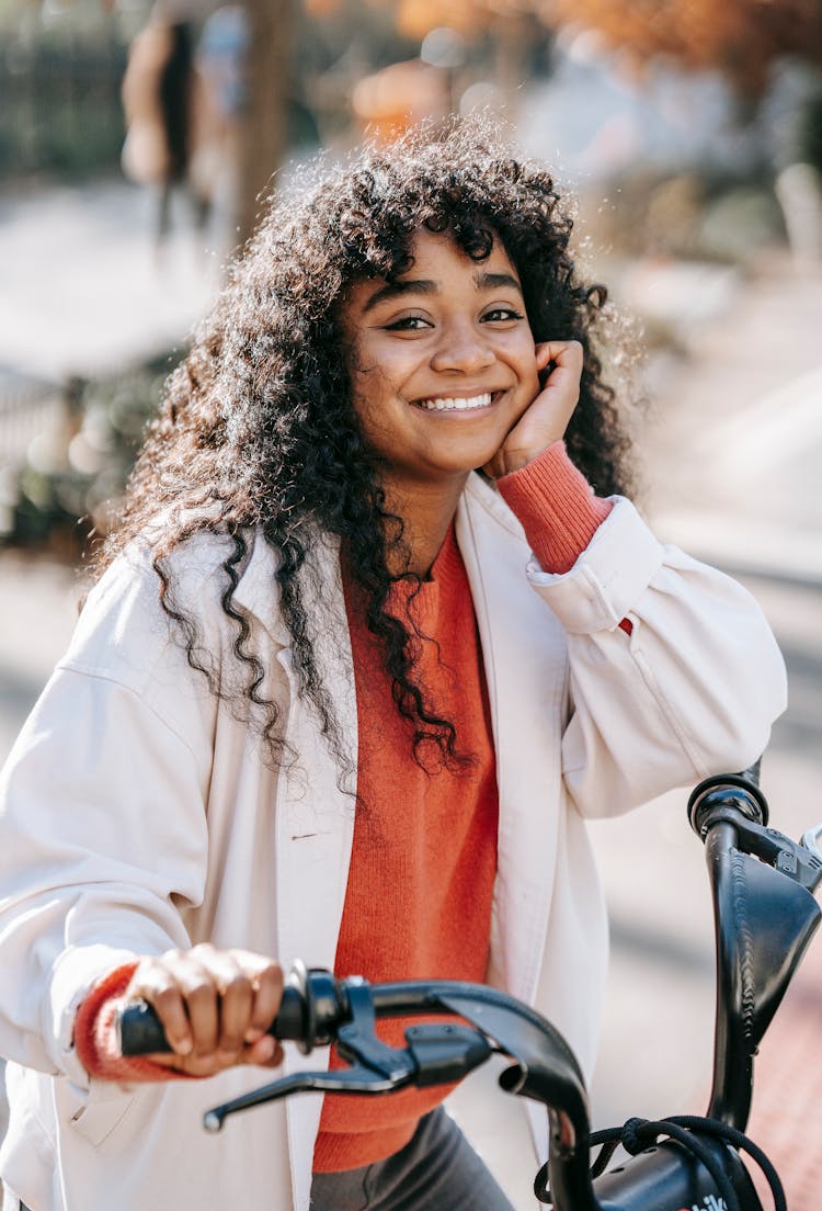 Happy Black Woman With Bicycle Standing On Sunny Street