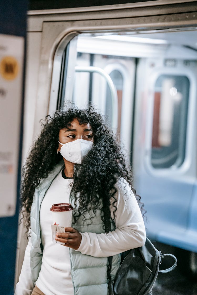 Black Woman In Mask Exiting Metro Train