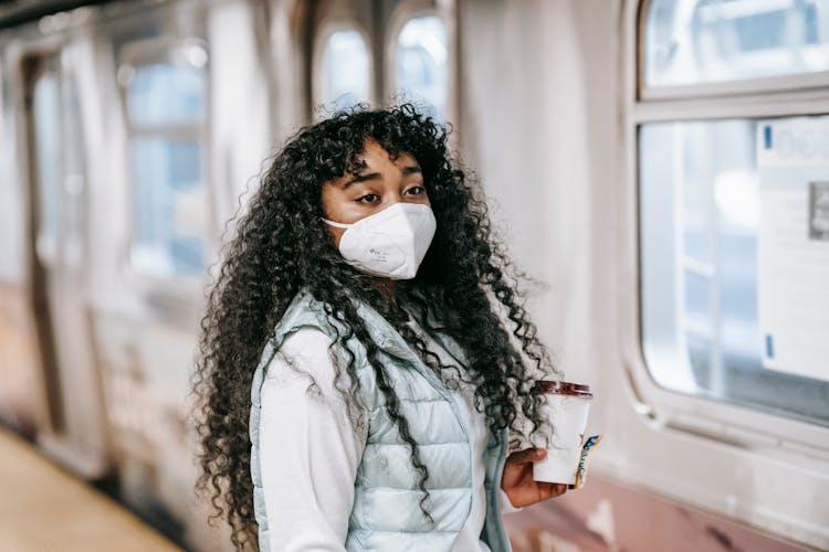 Black Woman In Mask Waiting To Enter Subway Train