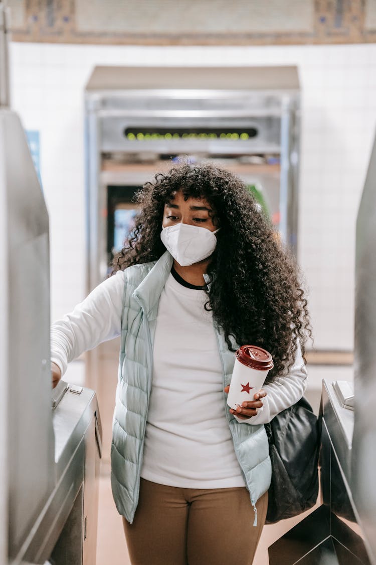 Black Woman Passing Through Turnstile In Metro