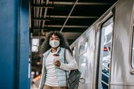 Black woman in mask leaving metro train