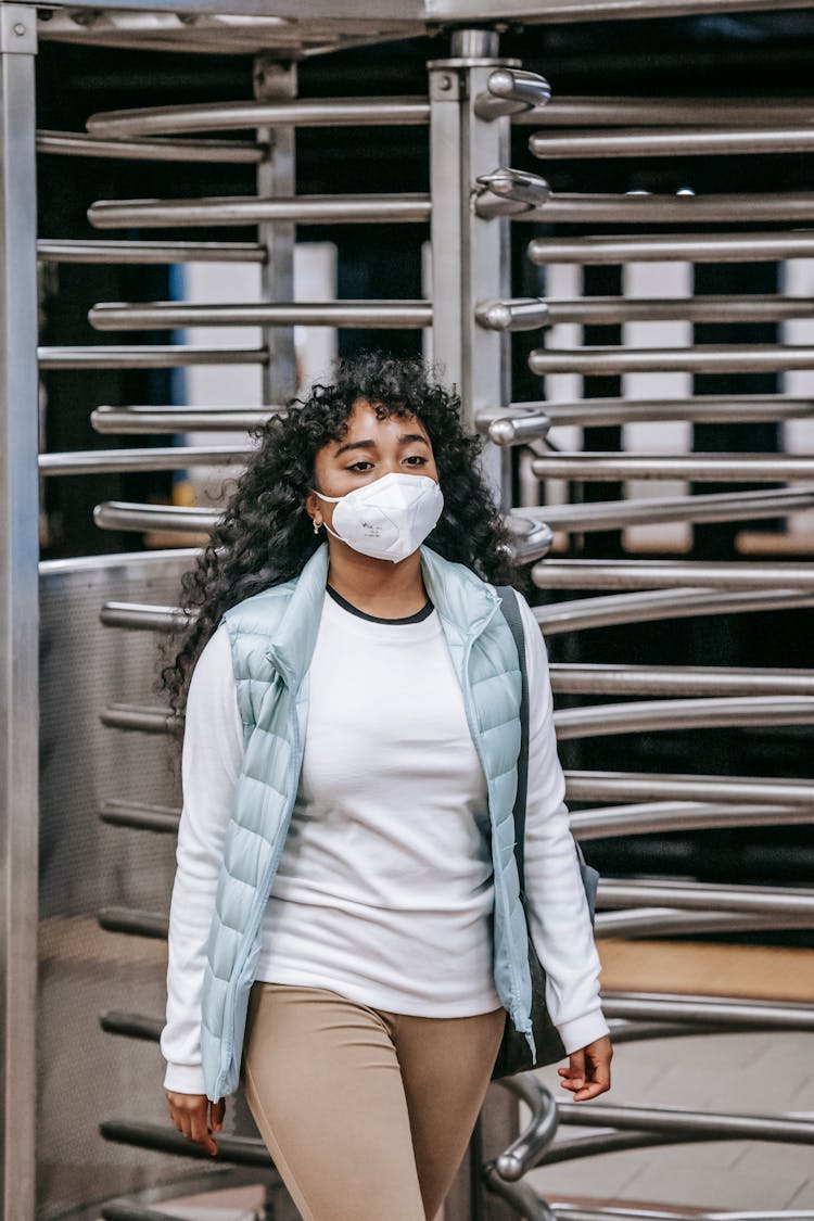 Serious Young Black Woman Walking On Street Near Security Turnstile