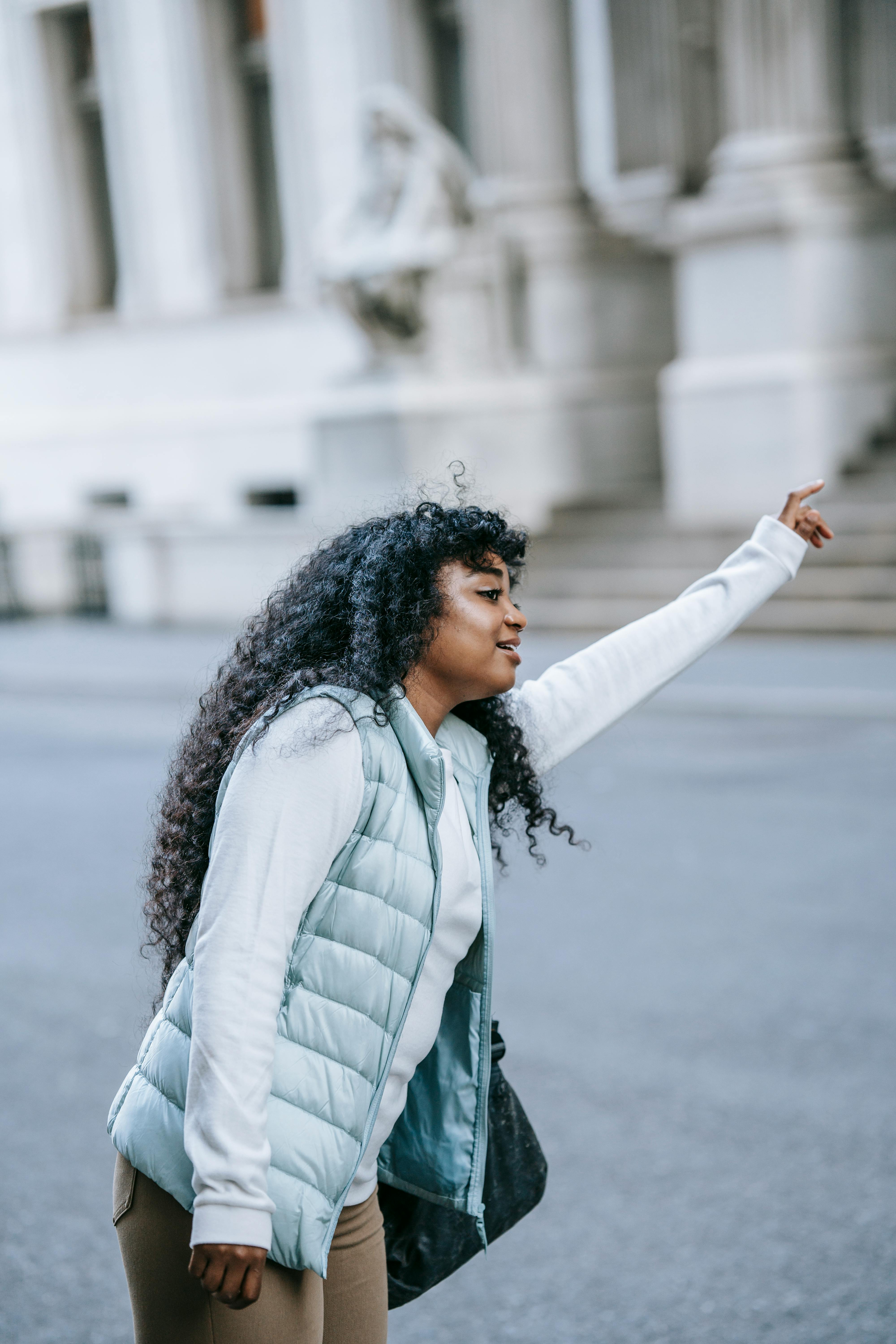 concentrated young african american woman catching cab on city street