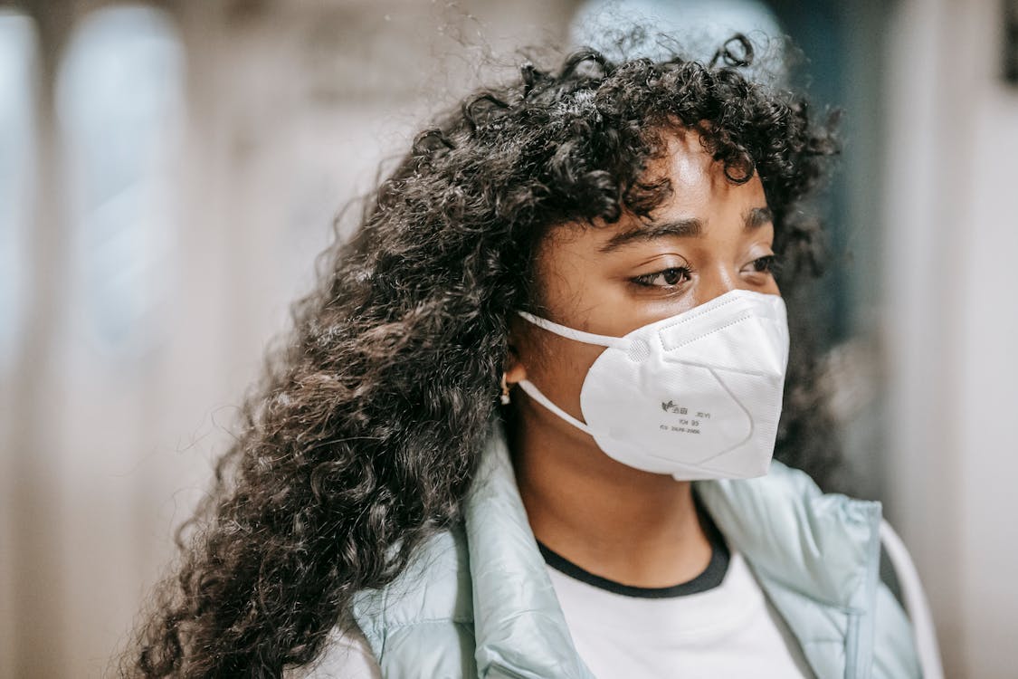 Woman in White Crew Neck Shirt Wearing White Face Mask