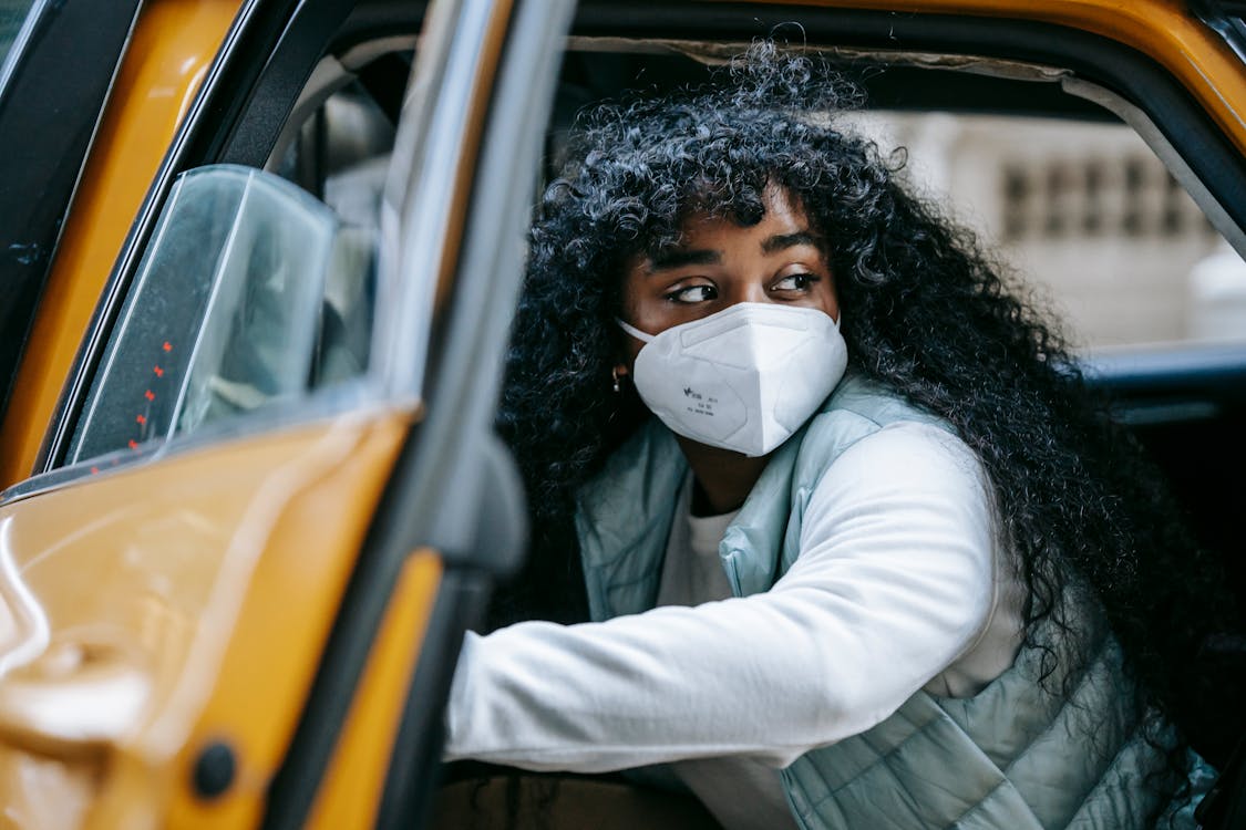 Free African American woman in mask in taxi on street Stock Photo