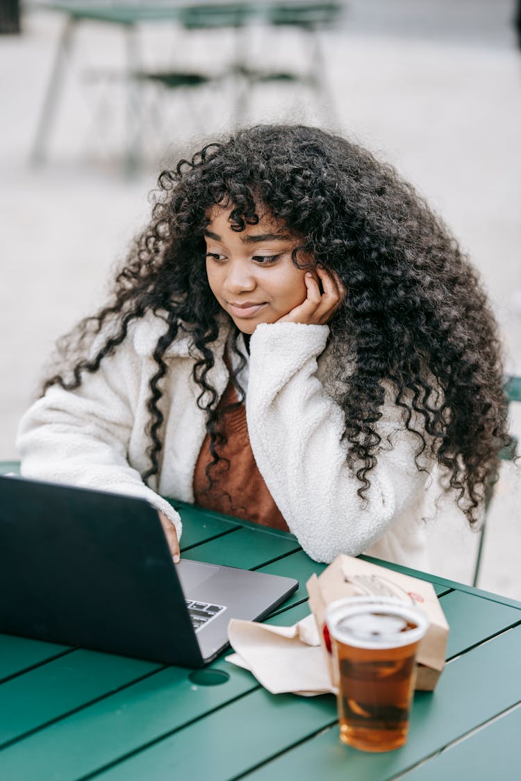 Black Woman With Glass Of Beer Using Laptop In Park