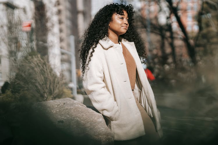 Positive Dreamy Black Woman Standing In Spring City Park