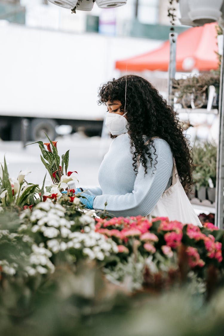 Black Woman Choosing Flowers In Street Shop