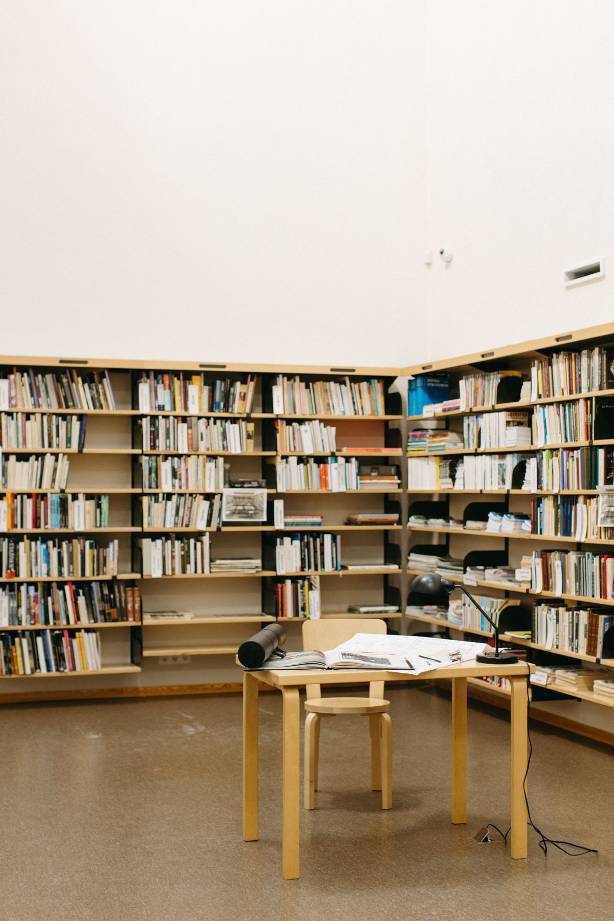 A quiet sunlit library room with a study table