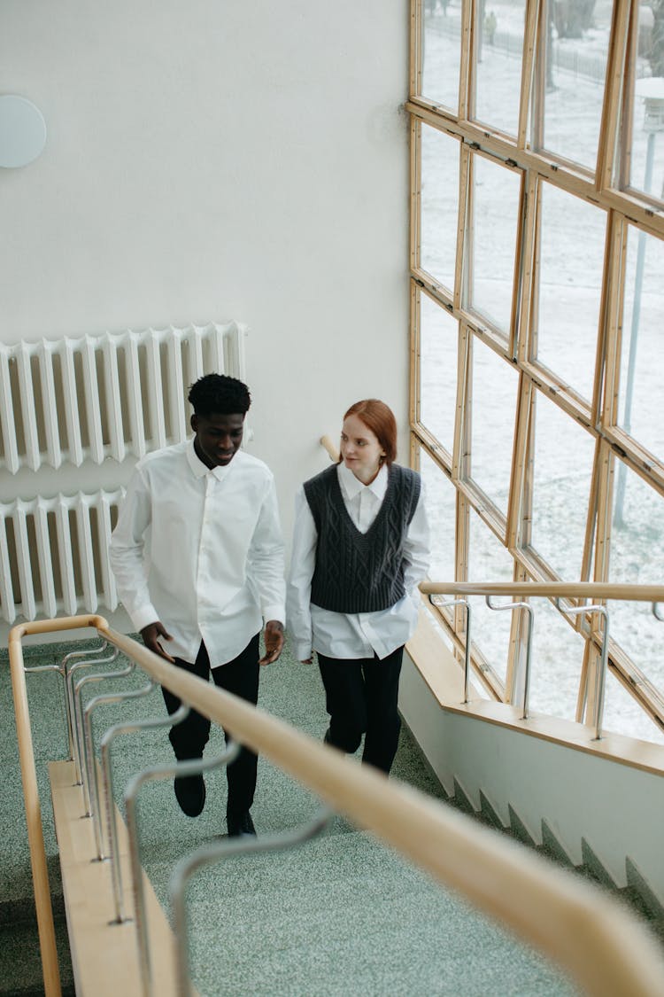 Man And Woman Climbing On Stairs In The Building