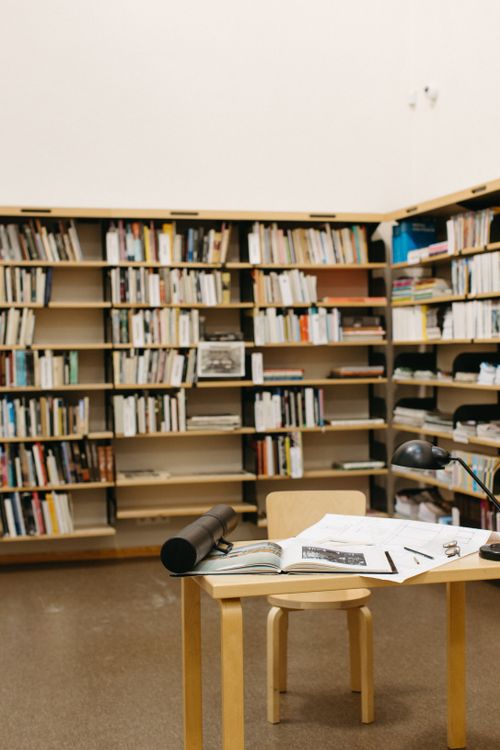 Free A serene library setting with bookshelves and a tidy workspace for research and reading. Stock Photo