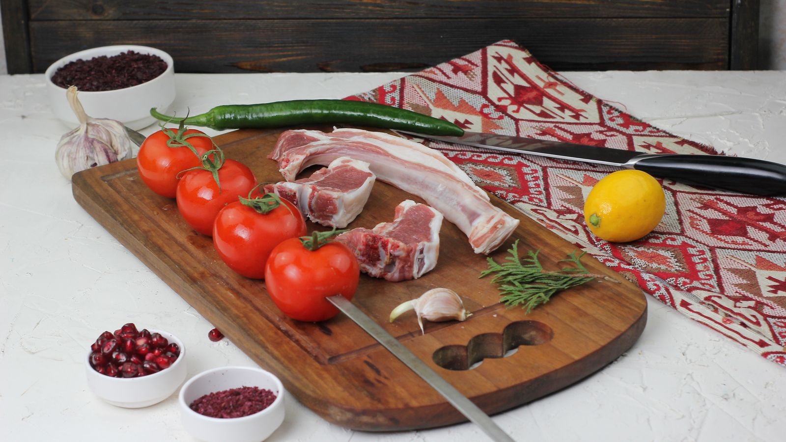 Raw lamb chops with tomatoes and spices on a wooden board — photo by Ragil Tagiyev on Pexels Raw lamb chops with tomatoes and spices on a wooden board