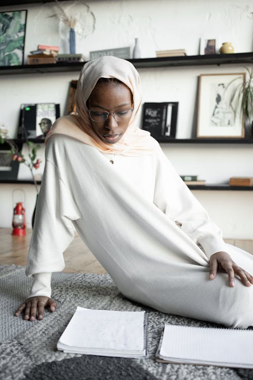 Femme En Hijab Blanc Assis Sur Un Textile à Carreaux Noir Et Blanc