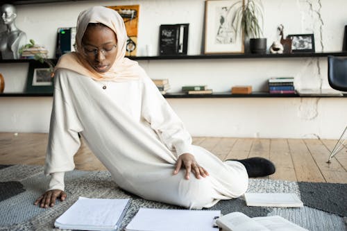 Black woman reading notes in notebook in living room