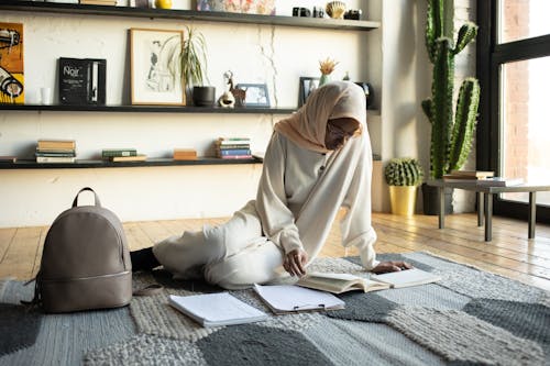 Free Concentrated black woman reading book during studies at home Stock Photo