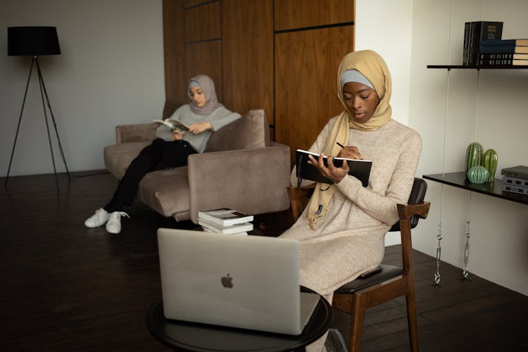 Diverse Muslim Women Studying And Reading Book