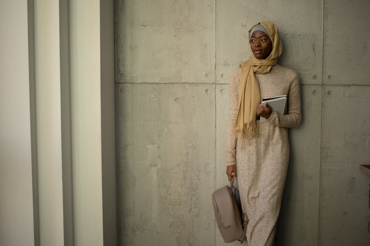 Serious Black Woman In Hijab With Backpack And Notebooks