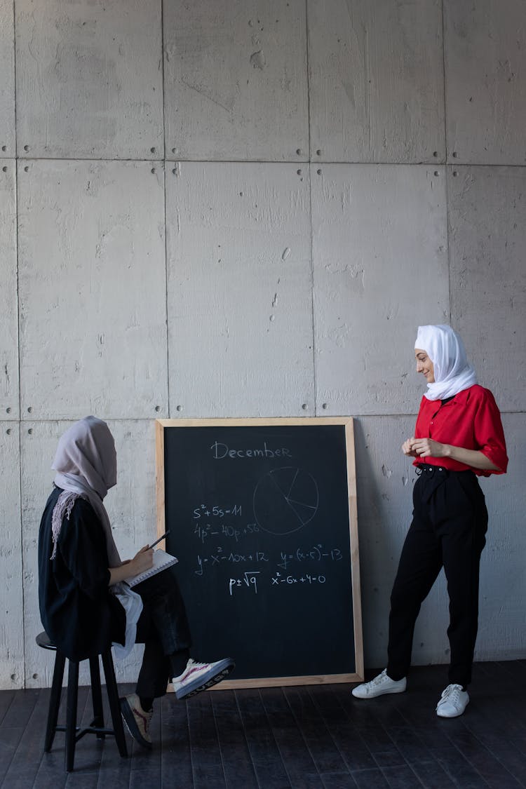 Diverse Islamic Women Discussing Plan Of Job On Blackboard