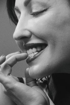 Grayscale side view of a smiling woman showcasing elegant facial features.