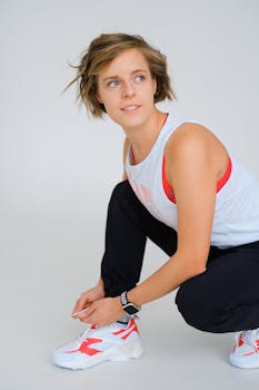 Young caucasian woman preparing for exercise, tying sneakers.