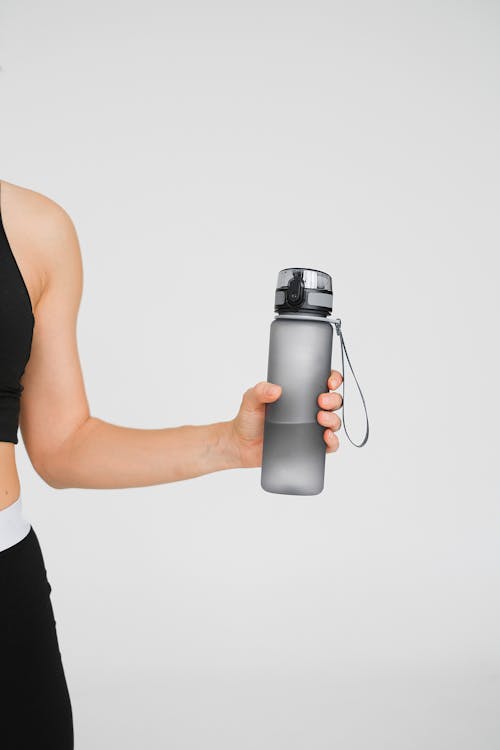 Premium Photo  Happy toned woman in sportswear holding flask