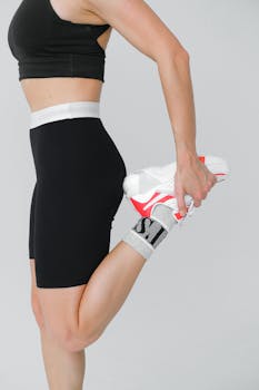 Close-up of a woman in athletic wear stretching leg for fitness.