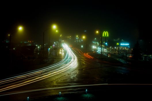 Night view of Lviv showing vibrant light trails, street lights, and illuminated landmarks.