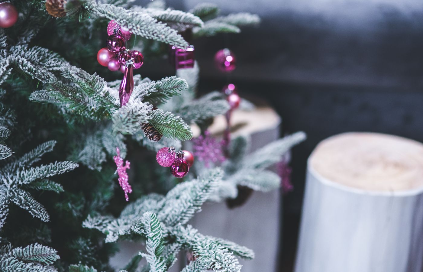 Close-up of a Christmas tree with frosted branches and pink ornaments, creating a festive holiday ambiance.