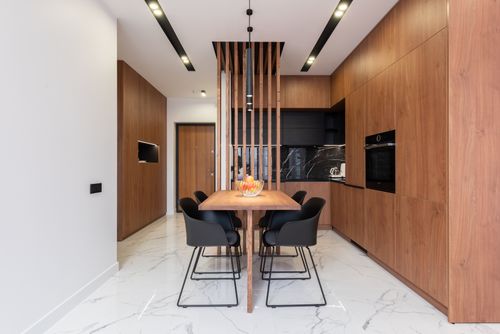 Free Table with chairs in spacious stylish kitchen with wooden furniture and modern appliances in luxury villa Stock Photo