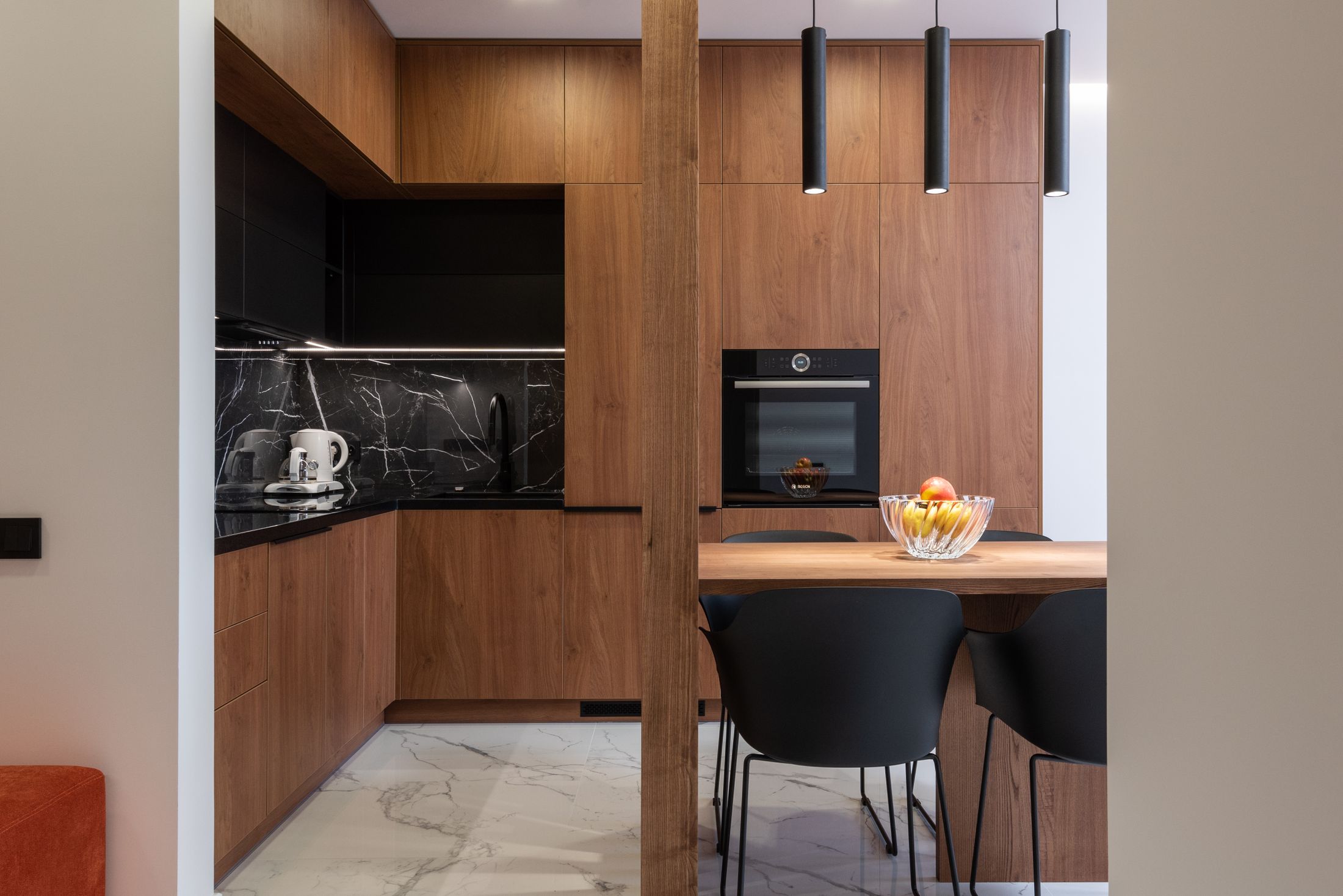 Kitchen with wooden cabinets and black accents wrapping the room