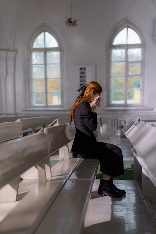 Free A Woman Crying while Sitting Inside the Church Stock Photo