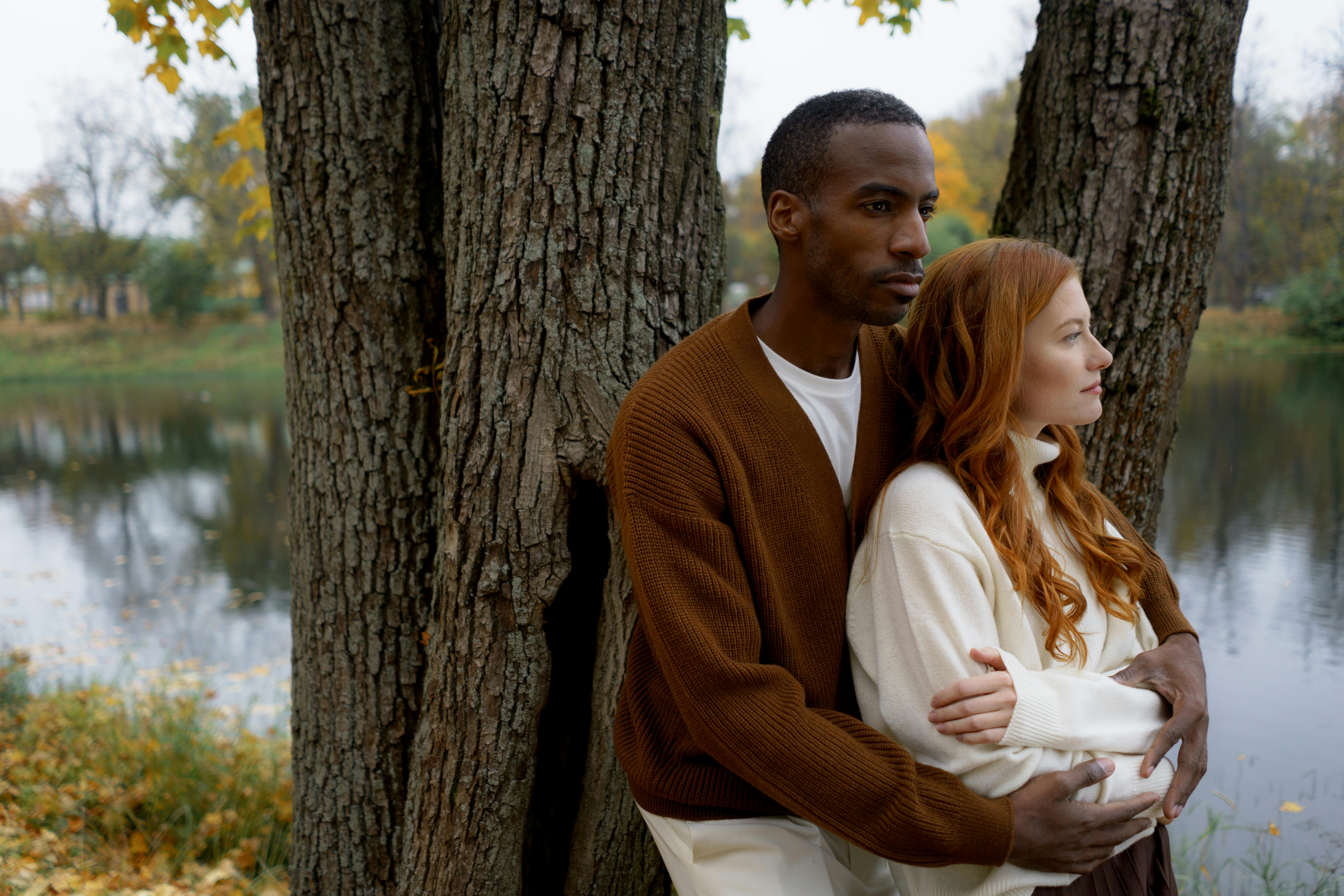 Man in Brown Knitted Cardigan Leaning on a Tree