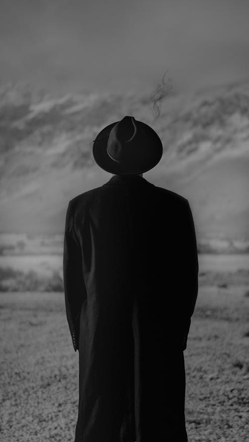 Free Back View of a Man Wearing a Hat and Coat Stock Photo
