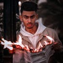 A Man Holding a Burning Newspaper