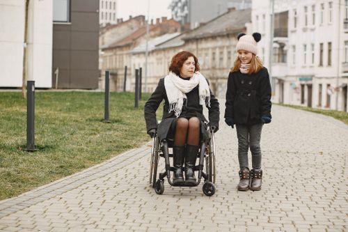 Person Pushing a Woman Sitting on a Wheelchair · Free Stock Photo