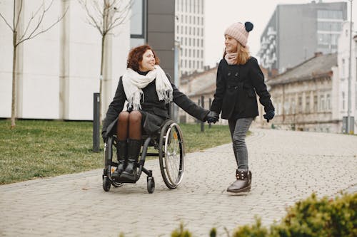 Girl Holding Hands with Woman on a Wheelchair